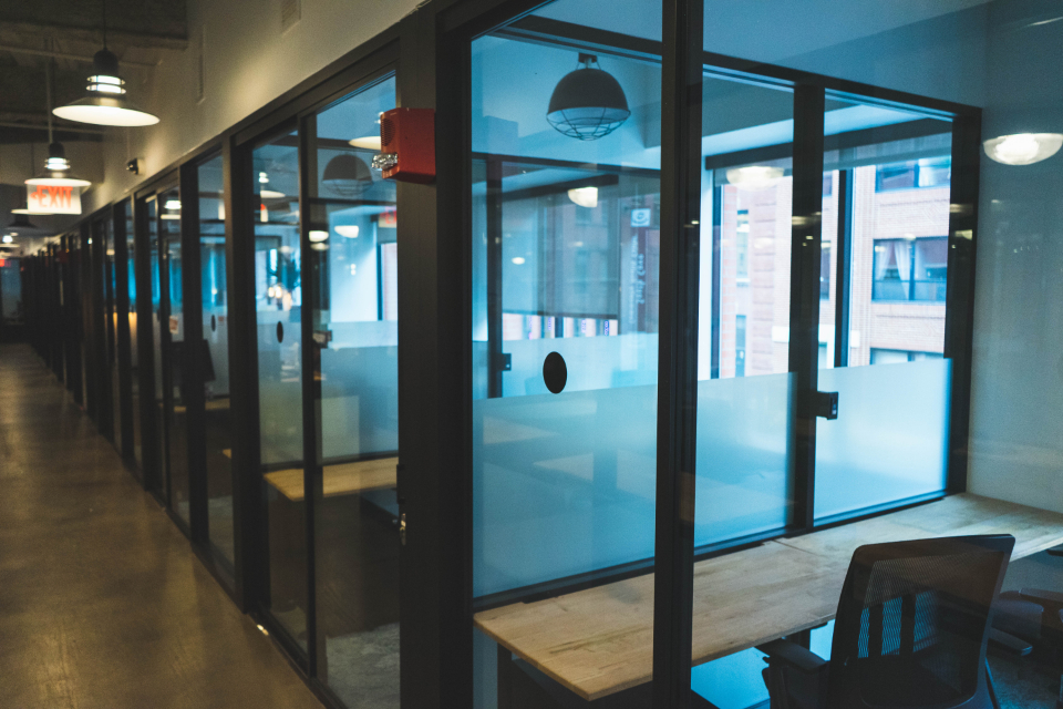 Cam bölmeli ofis koridoru ve çalışma masaları